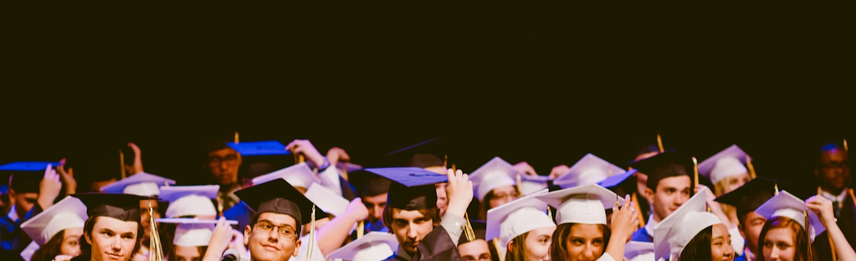 men and women wearing black and white graduation dress and mortar cap inside building