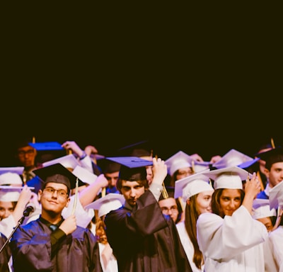 men and women wearing black and white graduation dress and mortar cap inside building