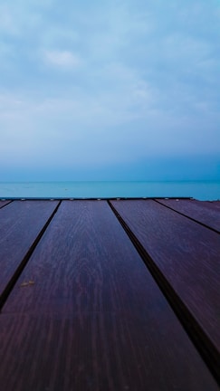 A peaceful pilates session on a wooden deck overlooking the blue sea.