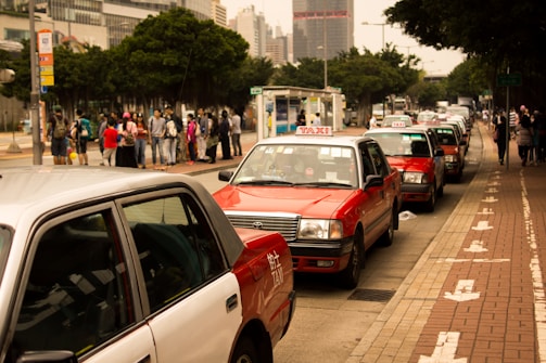 A fleet of taxis lined up ready for service in a city street