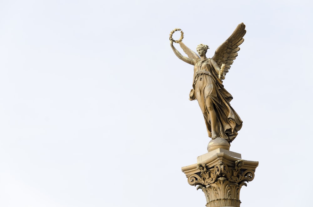 ángel sosteniendo una estatua redonda de corona]