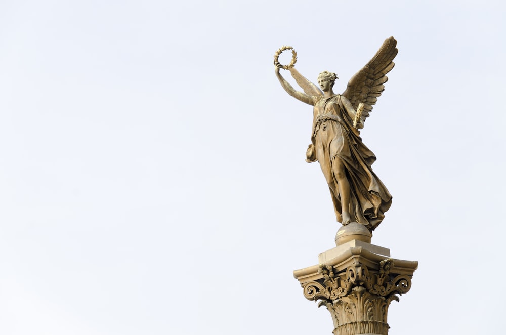 angel holding round wreath statue]