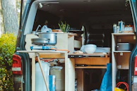 Interior shot of a food truck conversion showing custom kitchen layout with stainless steel appliances and ventilation.