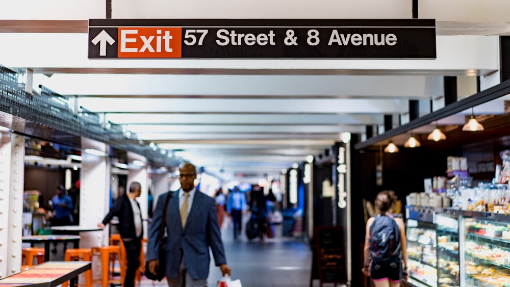 Flachfokusfotografie eines Mannes, der unter dem Tunnel der 57 Street und der 8 Avenue hindurchgeht