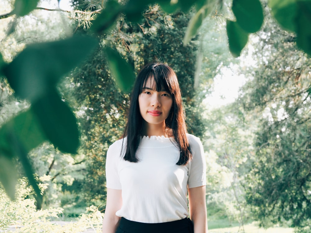 woman standing in middle of forest showing smile