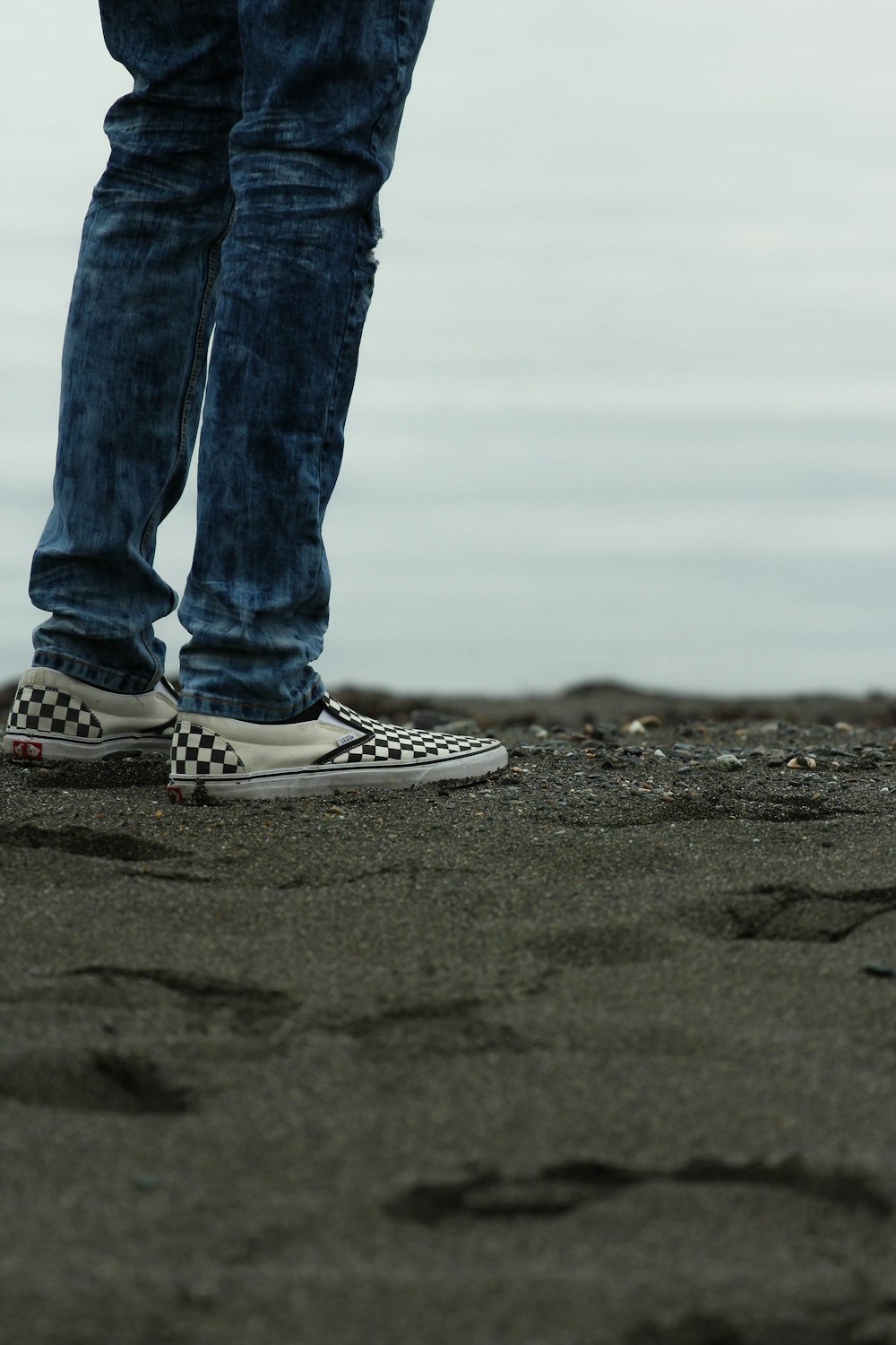 person standing on gray sands