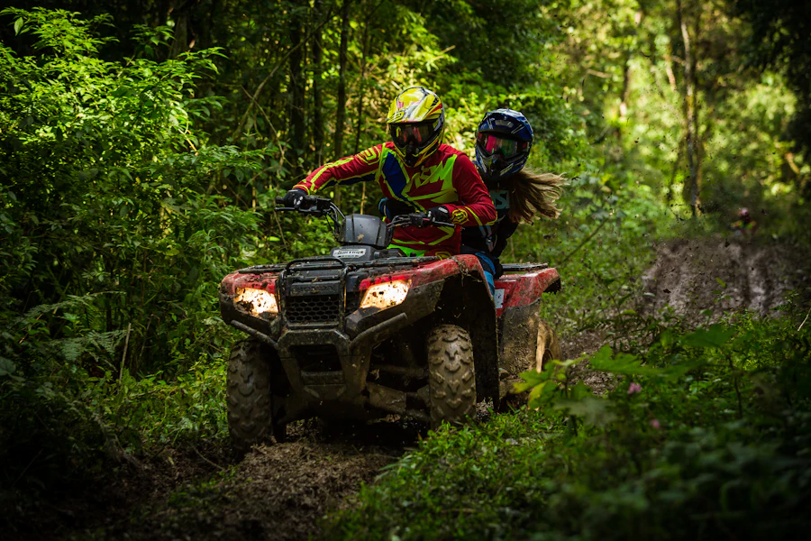 A man and a woman riding two-up on a quad bike