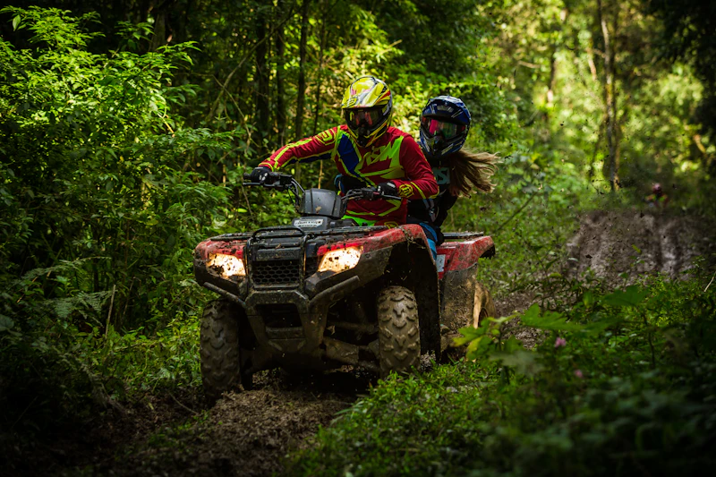 Quad bike riding through muddy jungle trail
