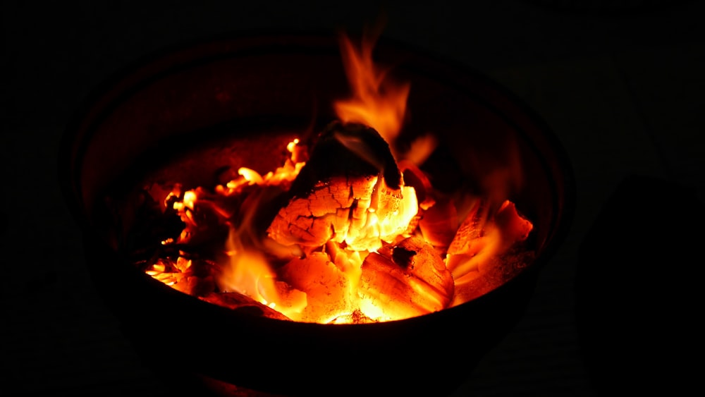 Quemar leña y carbones anaranjados en el fuego