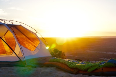 camping tent on cliff during golden hour; sleeping bag cleaning