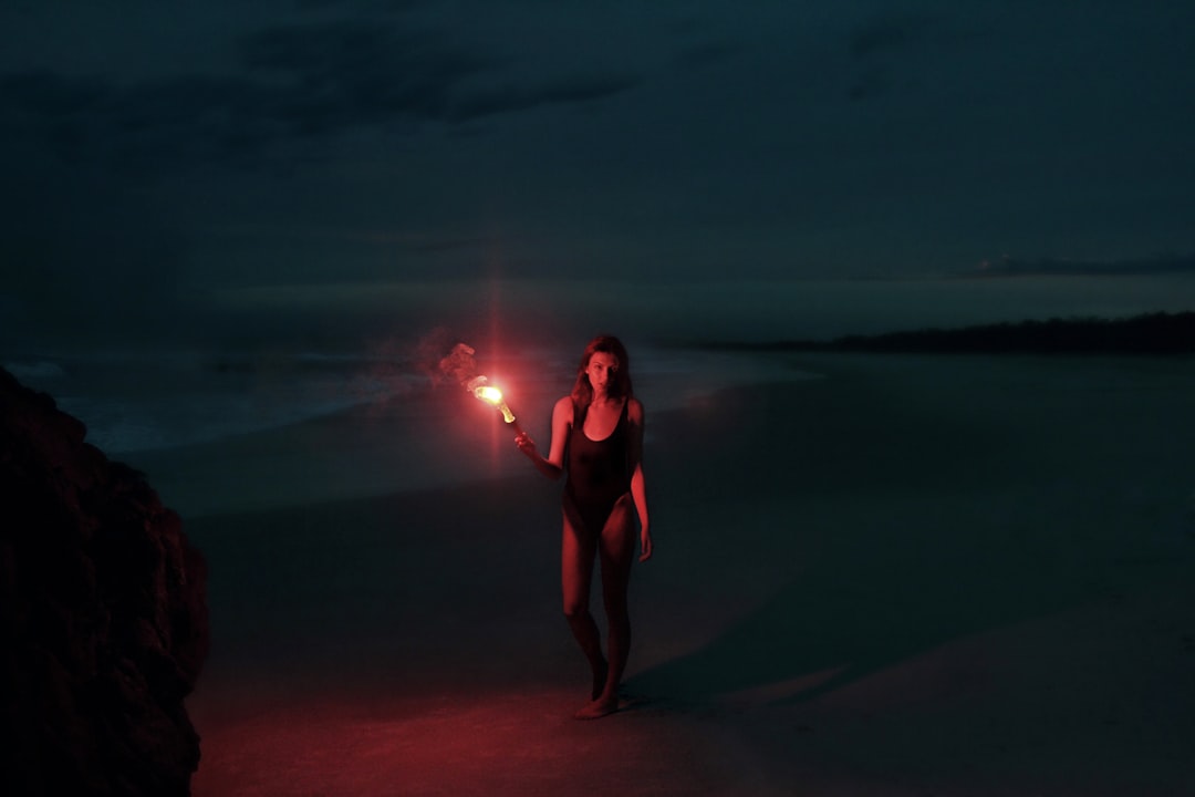 woman in one-piece swimsuit holding torch