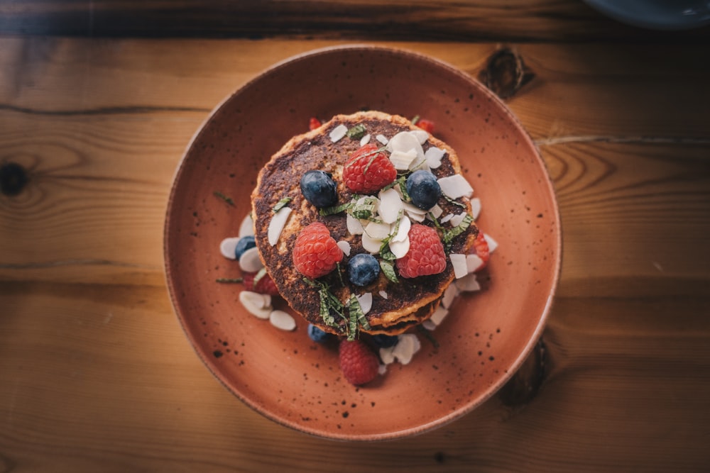 shallow focus photography of pancake with strawberries and blueberries on top