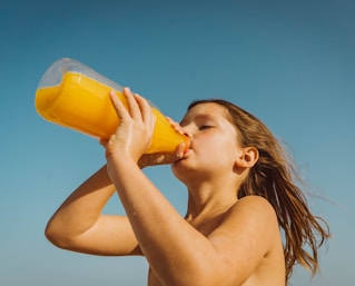 girl drinking yellow juice