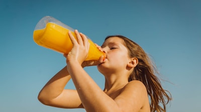 girl drinking yellow juice