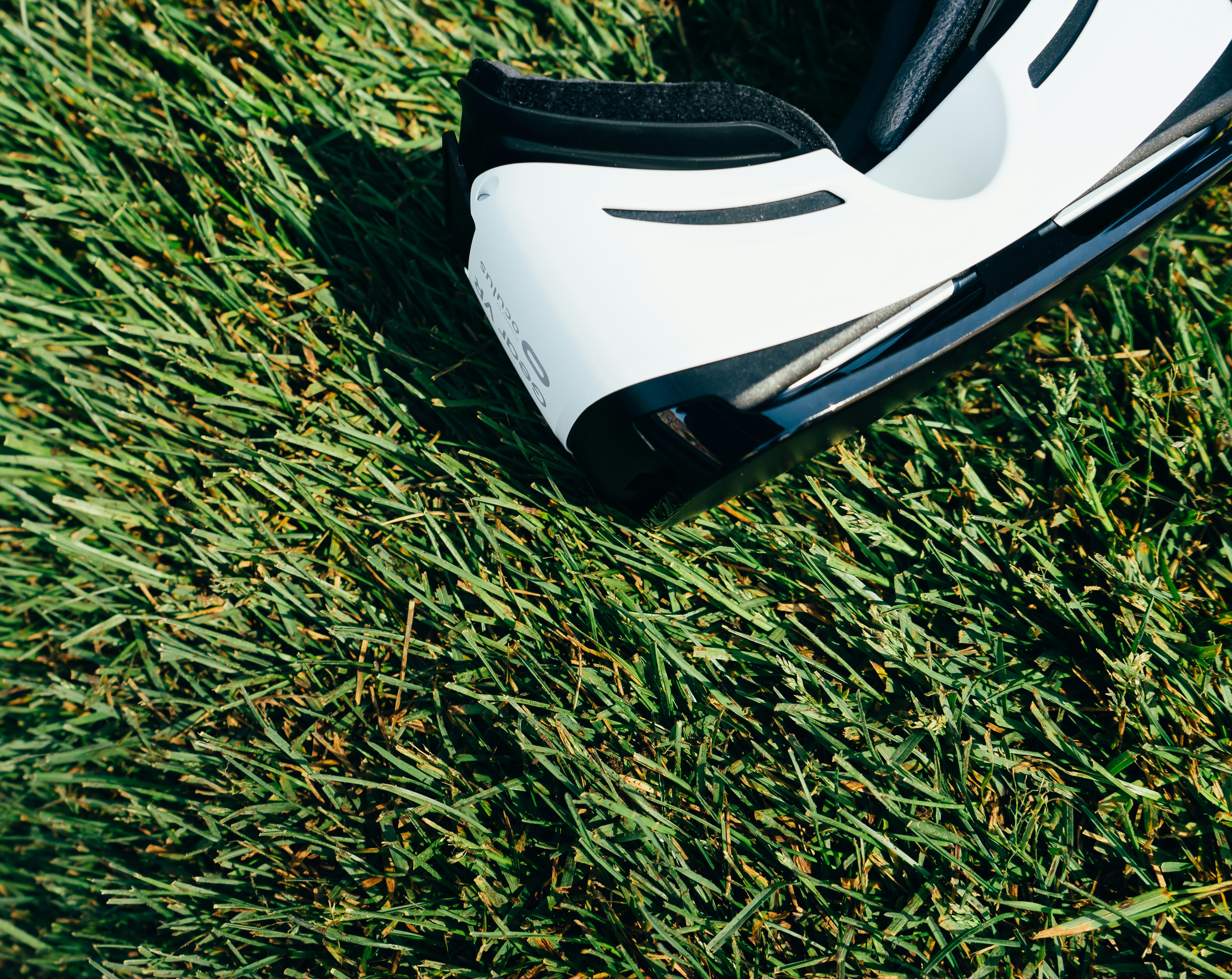 white and black VR Box headset on green grass field