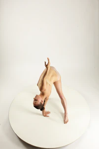 Sofie Dossi performing an impressive contortion pose on stage with a bright spotlight highlighting her.