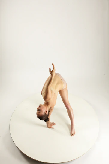 Sofie Dossi performing an impressive contortion pose on stage with a bright spotlight highlighting her.