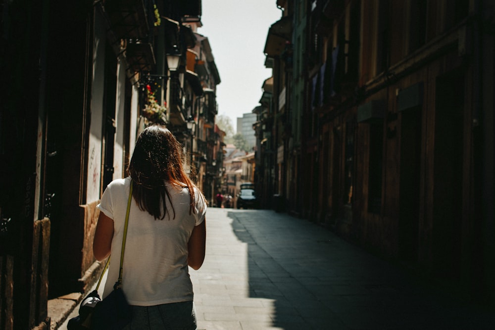 woman waking on pathway between houses