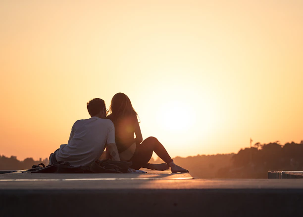 Couple sitting together at sunset, reflecting the group travel planner Canada offerings for couples 