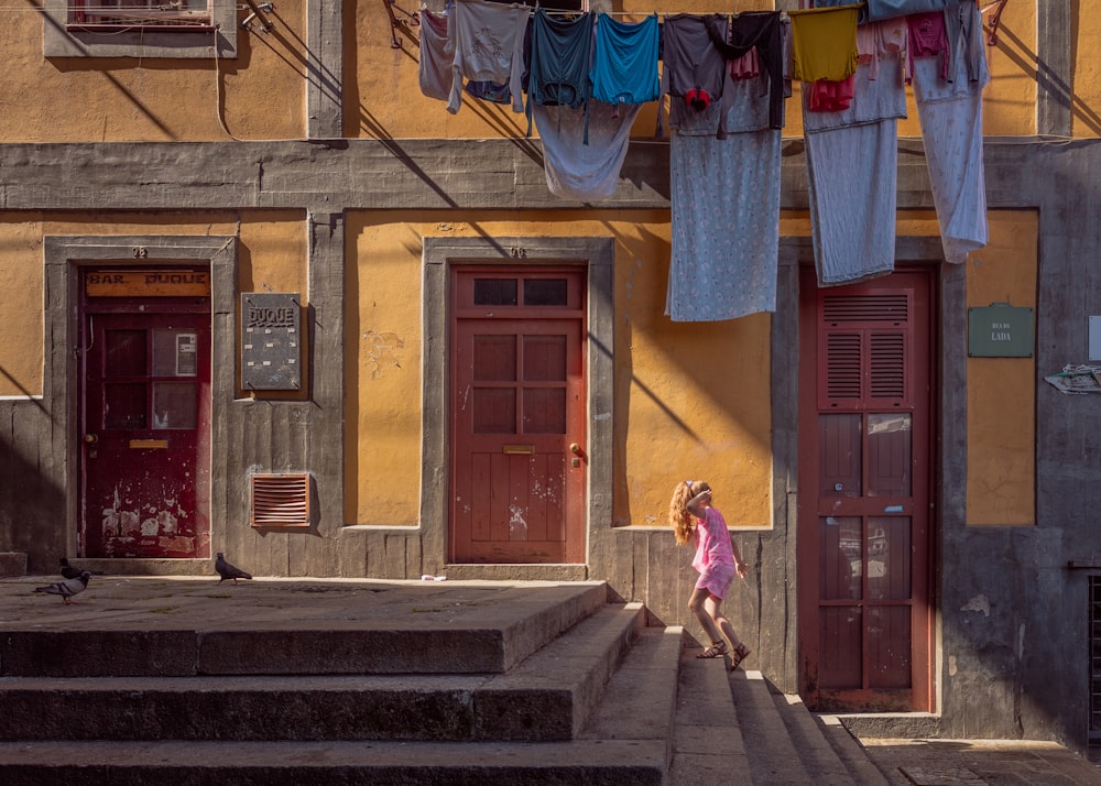 person walking on stairs beside brown door house