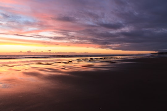 orange sunset in ocean in Port Waikato New Zealand