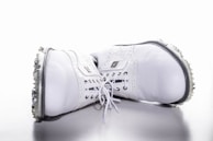 An elegant pair of golf shoes resting on a tee box with morning dew.
