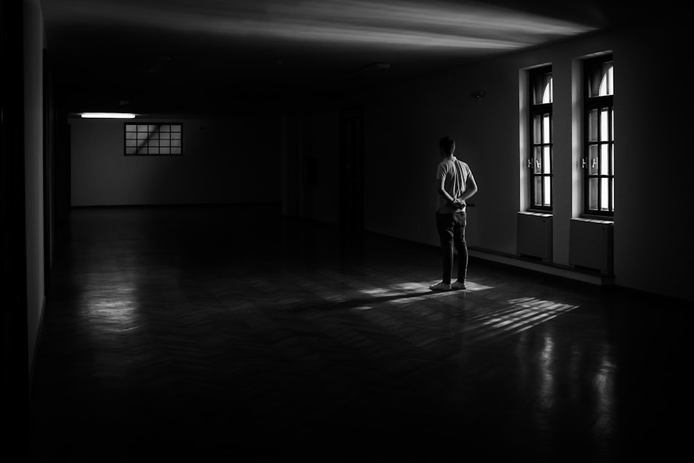 man standing near window inside house