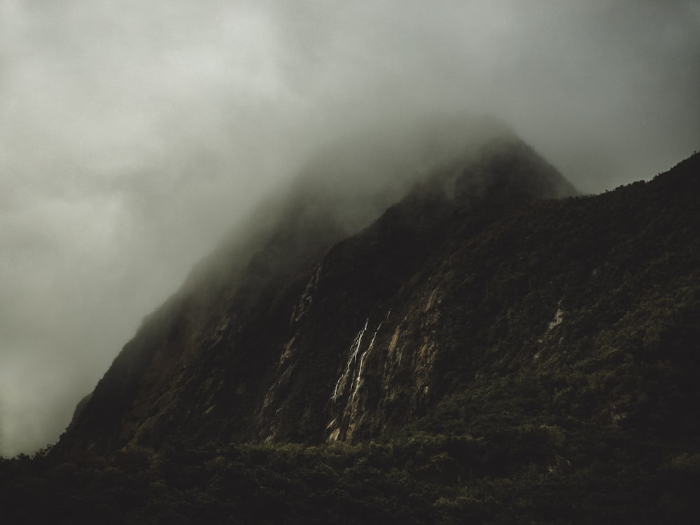 montaña gris cubierta por nubes blancas