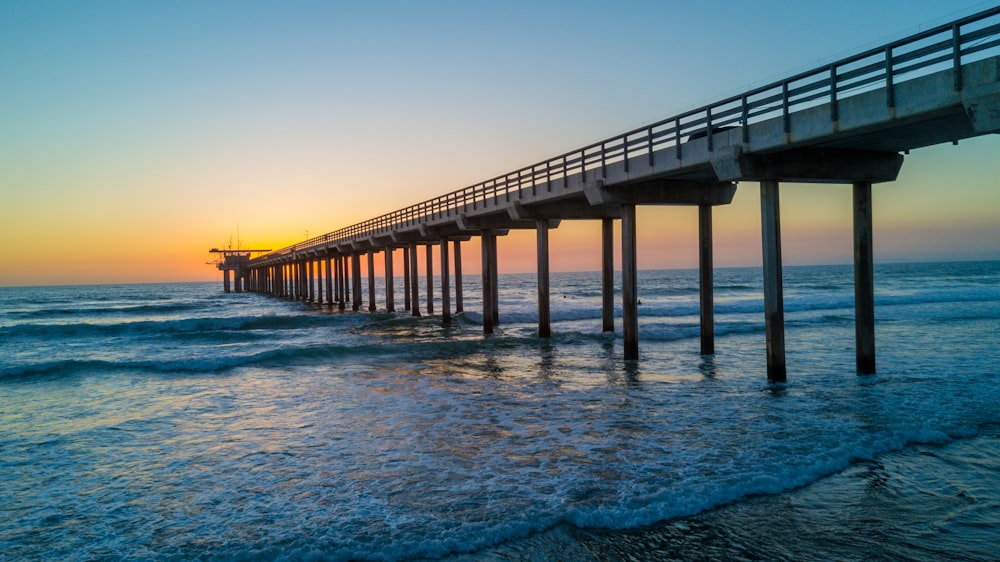 gray concrete bridge above sea water