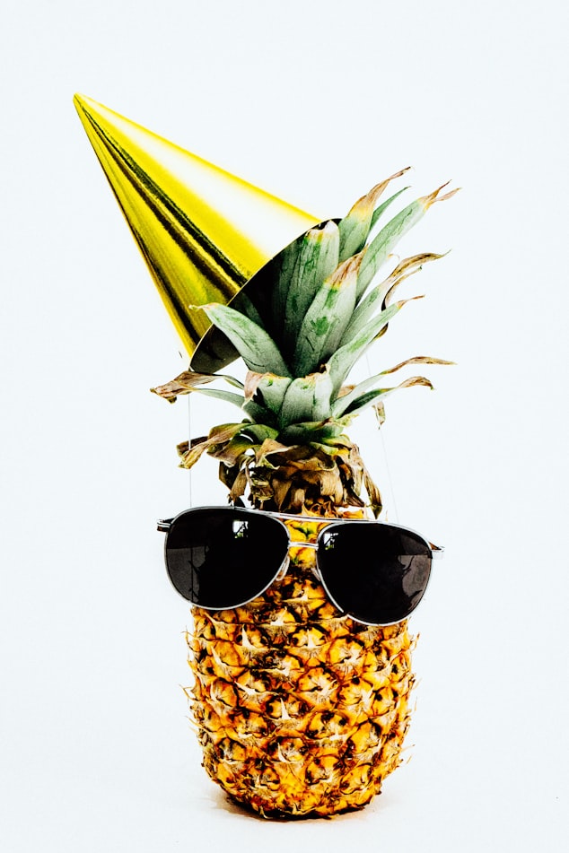 ripe pineapple with yellow cone and sunglasses
