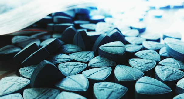 Close-up of assorted 7-hydroxymitragynine tablets in various colors and sizes.