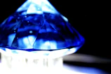 Close-up of a vibrant blue sapphire with natural facets reflecting light.