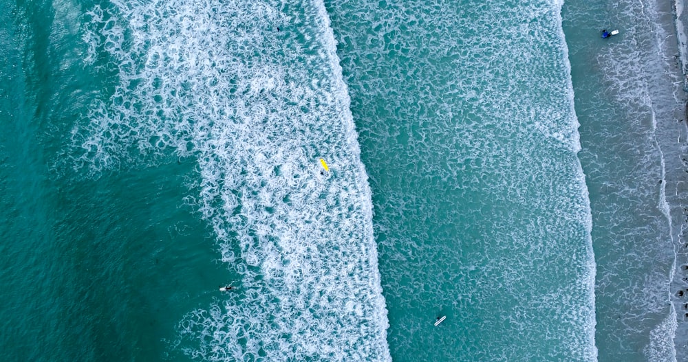 person carrying white surfboard on sea