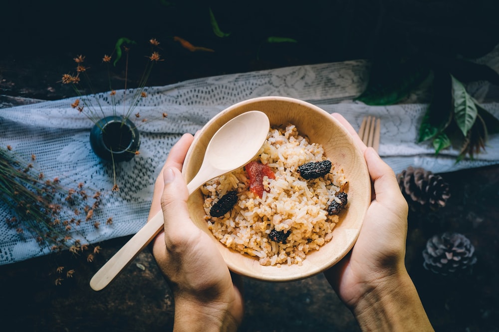 person holding bowl filled with food