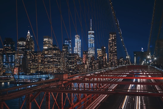 bridge near city buildings during nighttime