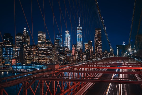 bridge near city buildings during nighttime in Brooklyn Bridge Park United States