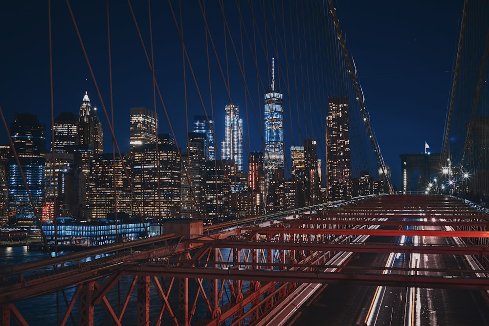 bridge near city buildings during nighttime