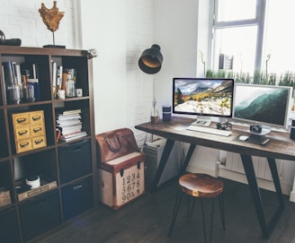 two flat screen monitor turned on near organizer rack inside the room