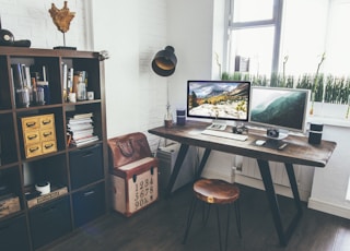 two flat screen monitor turned on near organizer rack inside the room