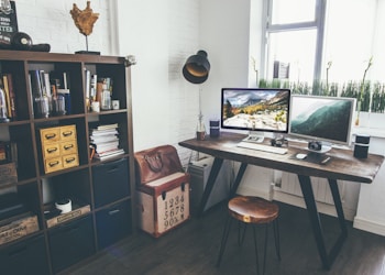 two flat screen monitor turned on near organizer rack inside the room