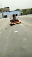 Close-up of a laser cleaning rust off a metal surface outdoors.