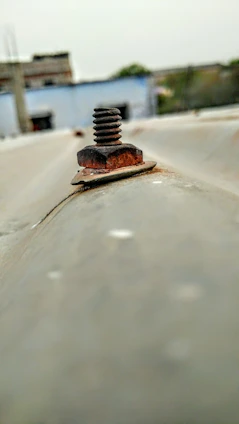 Close-up of a laser cleaning rust off a metal surface outdoors.