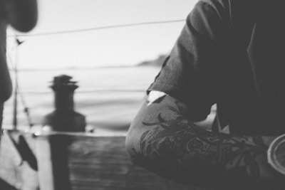 Traditional style tattoo of a ship on the upper arm.