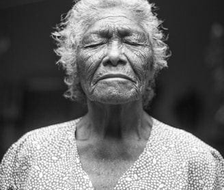 grayscale photo of closed-eyes woman