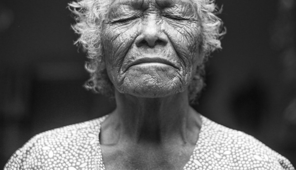 grayscale photo of closed-eyes woman