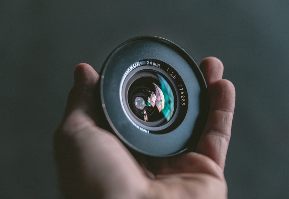 person holding black camera lens