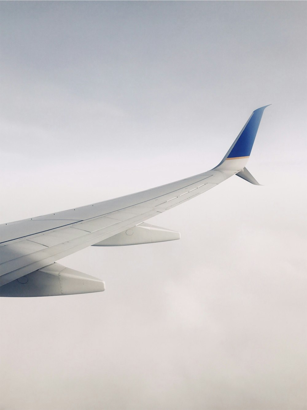 Avião branco e azul voando sobre nuvens durante o dia