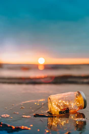 clear glass mason jar on beach during sunset