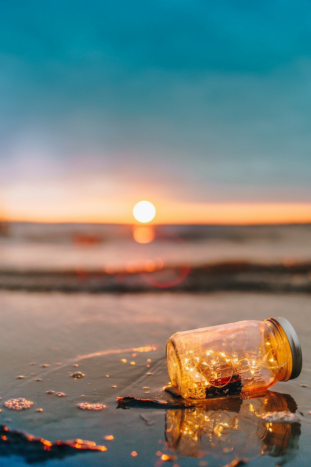Einmachglas aus klarem Glas am Strand während des Sonnenuntergangs