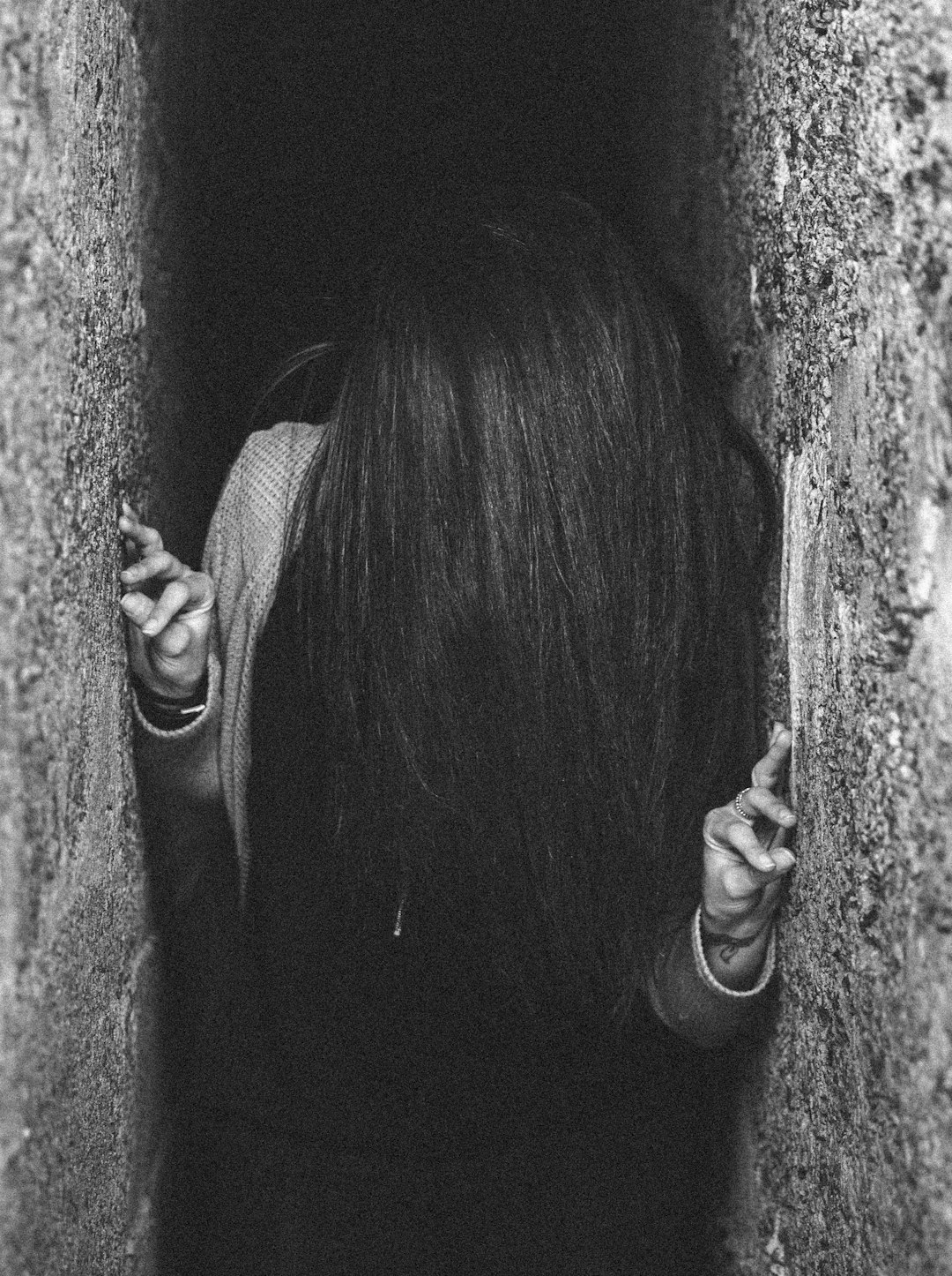 woman between gray concrete wall